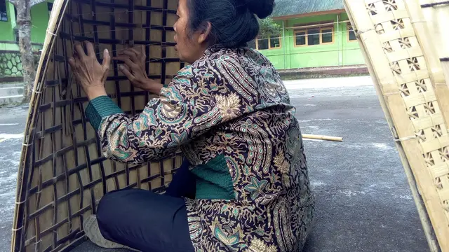 Mulyani, guru Seni SMPN 2 Selomerto Wonosobo memainkan bundengan di lapangan olahraga sekolah setempat, beberapa waktu lalu. (Foto: Liputan6.cm/Rudal Afgani Dirgantara)
