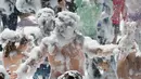 Orang tua dan anak-anak disemprot dengan busa oleh petugas pemadam kebakaran selama pesta di distrik Malasana Madrid, Spanyol, (4/5/2019). (AP Photo/Paul White)