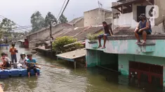 Warga melintas dengan perahu buatan saat banjir melanda perumahan Periuk Damai, Tangerang, Banten, Selasa (22/2/2021). Banjir setinggi 2,5 meter tersebut sudah terjadi selama 4 hari. (Liputan6.com/Angga Yuniar)