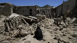 Wanita Afghanistan duduk di tengah kehancuran setelah gempa bumi di desa Gayan, di provinsi Paktika, Afghanistan, Jumat 24 Juni 2022. Lebih dari 1.000 orang dilaporkan tewas dan sedikitnya 1.500 orang terluka dalam gempa bumi dahsyat yang mengguncang Afghanistan pada Rabu 22 Juni 2022 dini hari. (AP Photo/Ebrahim Nooroozi)