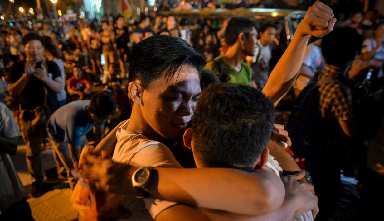 Sejumlah aktivis saling berpelukan setelah mendengar pemerintah Indonesia menunda pelaksanaan eksekusi hukuman mati terhadap Mary Jane, di depan Kedutaan Indonesia di Filipina, Rabu (29/4/2015). (REUTERS/Ezra Acayan)