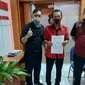 Kongko Windani, bersama kader Kepala Badan Bantuan Hukum dan Advokasi Rakyat (BBHAR) PDIP Surabaya Arif Budi Santoso, membawa stiker tersebut kepada pihak kepolisian. (Foto: Liputan6.com/Dian Kurniawan)