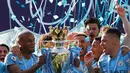 Pemain Manchester City Vincent Kompany (kiri) mengangkat trofi Liga Inggris usai mengalahkan Brighton di Stadion AMEX, Brighton, Inggris, Minggu (12/5). The Citizens menjadi yang terbaik di musim 2018-2019 usai memenangi duel sengit dengan Liverpool hingga pekan terakhir. (AP Photo/Frank Augstein)