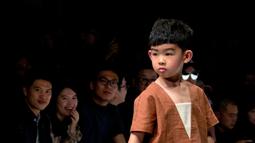 Gaya model cilik berpose mengenakan koleksi busana orang tua dan anak YIAN karya Lu Enhua selama China Fashion Week di Beijing, Sabtu 1 April 2017. (AP Photo / Mark Schiefelbein)