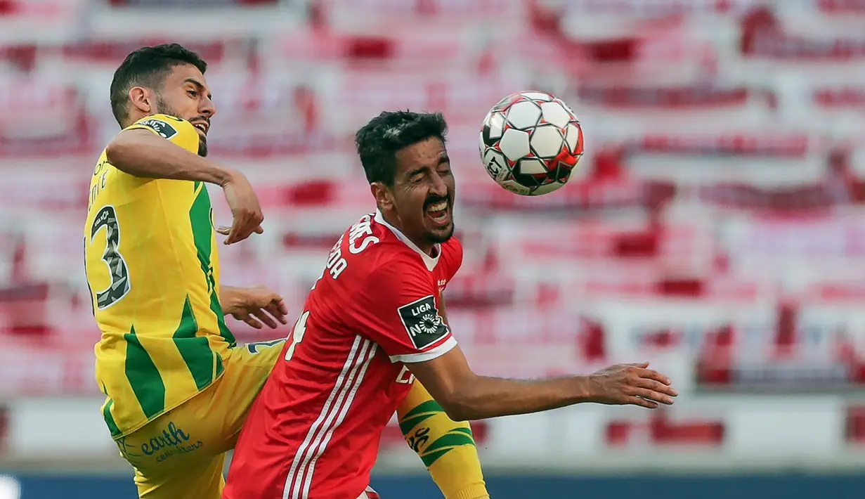 Bek Benfica, Andre Almeida, berebut bola dengan bek Tondela, Yohan Tavares, pada laga Liga Portugal di Stadion The Luz, Lisbon, Kamis (4/6/2020) waktu setempat. Kompetisi Liga Portugal resmi dilanjutkan dengan aturan tanpa penonton di setiap pertandingan. (AFP/Tiago Petinga/pool)