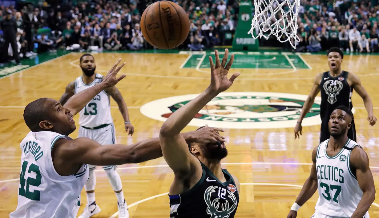 Pemain Boston Celtics, Al Horford (42) menghalau tembakan pemain Milwaukee Bucks, Jabari Parker (12) pada laga playoffs NBA basketball di TD Garden, Boston, (24/4/2018). Celtics menang  92-87. (AP/Charles Krupa)