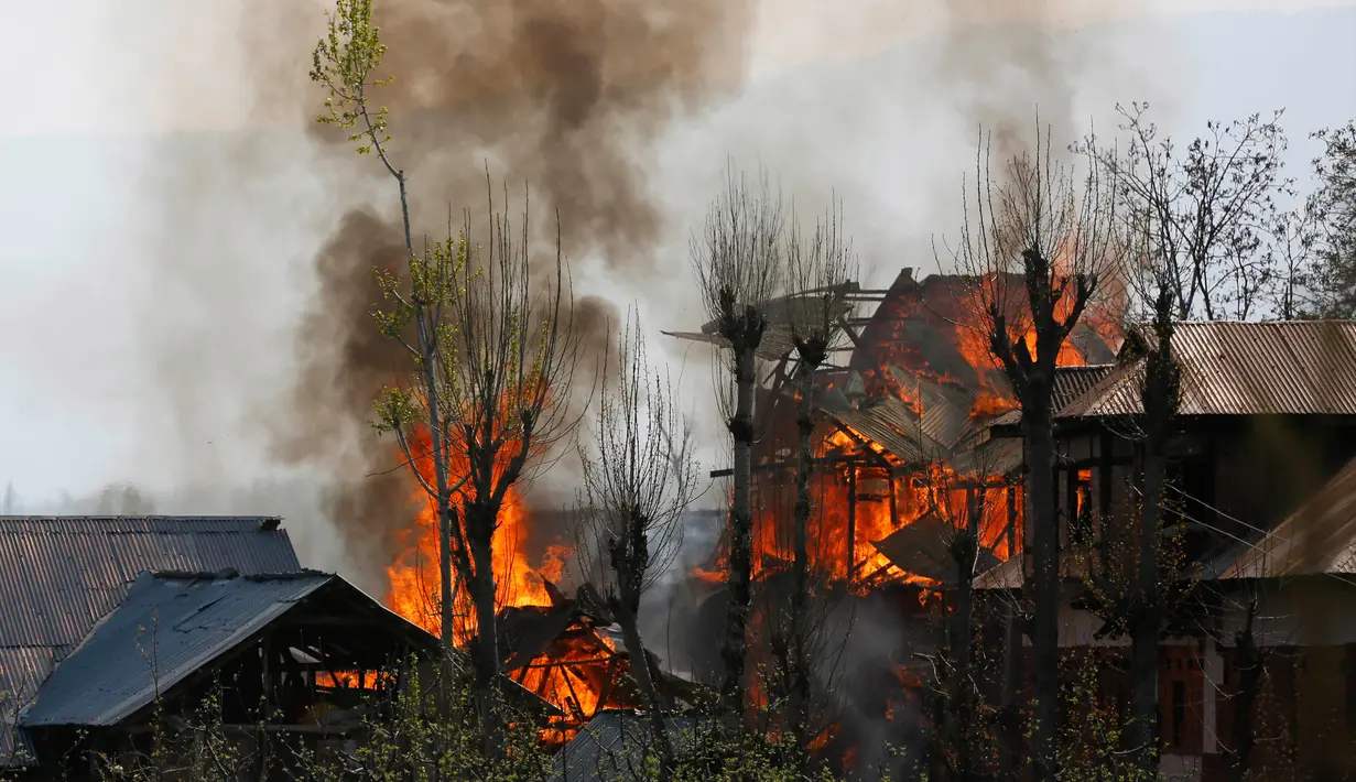 Sejumlah bangunan tempat tinggal terbakar akibat pertempuran senjata antara kelompok militan dan pasukan keamanan India di Shopian, Srinagar (4/1). Situasi wilayah ini kian memanas dan sering terjadi bentrokan. (AP Photo / Mukhtar Khan)