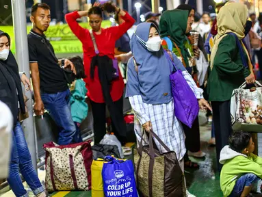 Pemudik pejalan kaki berada di gang way menuju kapal di Dermaga 3 Pelabuhan Merak, Cilegon, Banten, Sabtu (6/4/2024). (Liputan6.com/Angga Yuniar)