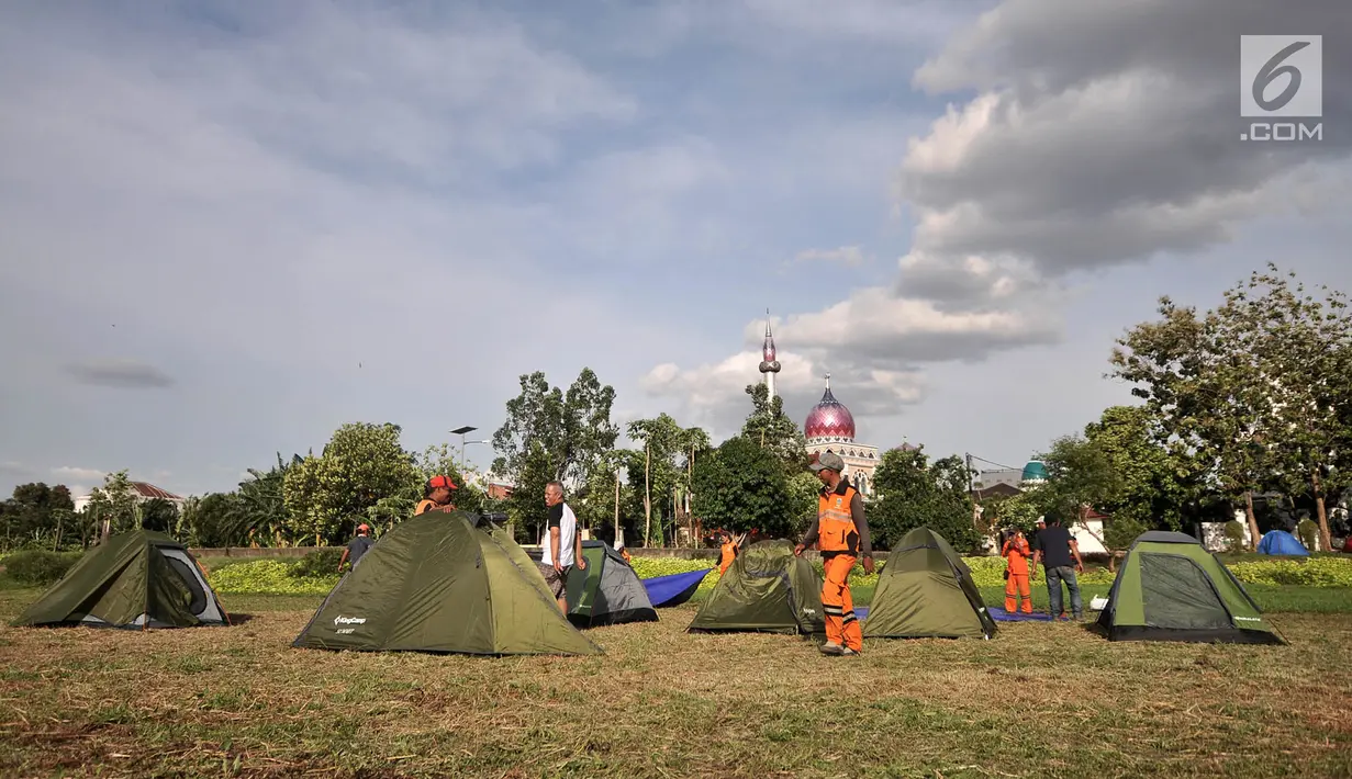 Petugas Penanganan Prasarana dan Sarana Umum (PPSU) mendirikan tenda saat persiapan untuk doa bersama pada malam Tahun Baru di Cipinang Melayu, Jakarta, Minggu (30/12). (Merdeka.com/ Iqbal S. Nugroho)