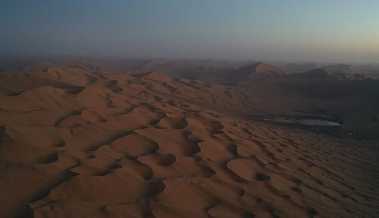 Foto dari udara yang diabadikan saat malam hari pada 30 Mei 2020 ini menunjukkan Danau Daghtu di Gurun Badain Jaran, Daerah Otonom Mongolia Dalam, China utara. Menurut pemandu wisata setempat, warna merah muda pada Danau Daghtu disebabkan oleh mineral garam di dasar danau tersebut. (Xinhua/Xu Qin)