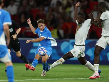 Bek Israel #12 Noam Ben Harosh menendang bola melewati bek Mali #04 Mamadou Tounkara pertandingan Grup D Olimpiade 2024 di Stadion Parc des Princes, Prancis, Kamis (25/7/2024) dini hari WIB. (FRANCK FIFE / AFP)