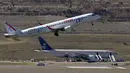Pesawat Europa Airlines terbang melewati Saudi Arabian Airlines penerbangan SVA 226 yang terisolasi di landasan setelah penumpang dan kru dievakuasi menyusul ancaman bom, di bandara Barajas di Madrid, Spanyol, Kamis (4/2/2016). (REUTERS/Sergio Perez)