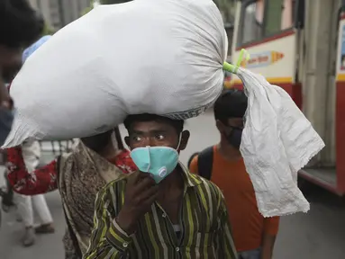 Seorang pekerja migran tiba di terminal bus untuk menuju desanya setelah lockdown diberlakukan di ibu kota India, New Delhi, Selasa (20/4/2021). India melaporkan 259.170 infeksi baru dan 1.761 kematian akibat Covid-19 dalam 24 jam terakhir. (AP Photo/Manish Swarup)