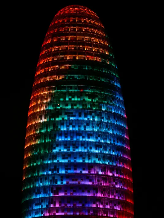Proyeksi cahaya warna pelangi menerangi gedung pencakar langit Torre Agbar saat peringatan World Pride di Barcelona, Spanyol, 28 Juni 2017. World Pride merupakan acara perayaan LGBT terbesar di dunia yang diadakan setiap tahun. (AP/Manu Fernandez)