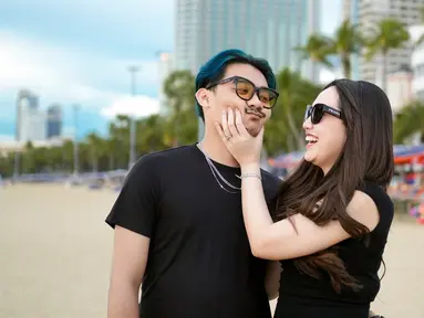 Latar belakang pantai dengan hamparan pasir putih memperlihatkan momen santai keduanya di tengah kesibukan untuk manggung. Potret tersebut menunjukkan sisi lain dari Happy Asmara yang biasanya terlihat di atas panggung, kali ini ia menikmati momen indah bersama orang yang dicintainya. (Liputan6.com/IG/@happy_asmara77)