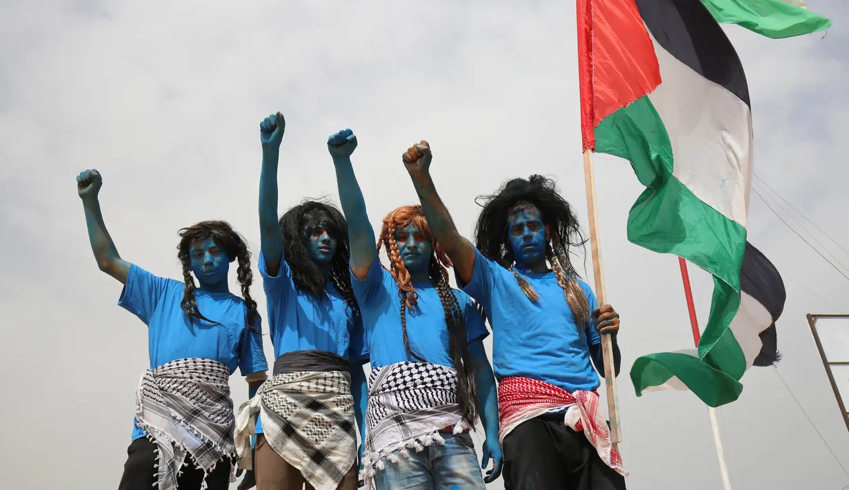 Warga Palestina bergaya seperti karakter dari film "Avatar" berpose selama protes menuntut hak untuk kembali ke kampung halaman mereka di perbatasan Israel-Gaza, Timur Khan Yunis di Gaza selatan Strip, (4/5). (AFP Photo/Said Khatib)