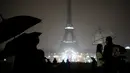 Pengunjung berkumpul di alun-alun Trocadero ketika lampu Menara Eiffel dipadamkan di Paris, Senin (2/10). Pemadaman lampu menara yang menjadi ikon Negara Prancis ini sebagai bentuk penghormatan untuk korban penembakan di Las Vegas. (AP/Kamil Zihnioglu)