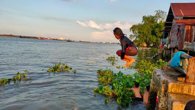 Melompat dan berenang di aliran Sungai Musi, menjadi aktifitas seru anak-anak yang tinggal di tepian Sungai Musi Palembang (Liputan6.com / Nefri Inge)