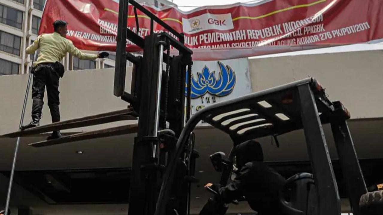 Pemasangan spanduk tersebut dilakukan dengan bantuan kendaraan forklift.