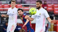 Penyerang Barccelona, Lionel Messi, berebut bola dengan bek Real Madrid, Nacho Fernandez, pada laga lanjutan Liga Spanyol di Camp Nou Stadion, Sabtu (24/10/2020) malam WIB. Real Madrid menang 3-1 atas Barcelona. (AFP/Lluis Gene)