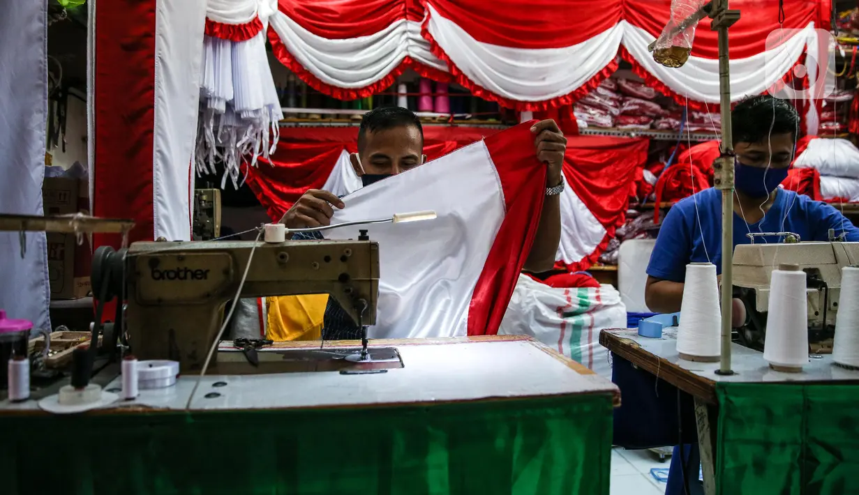 Aktivitas penjahit bendera merah putih di kiosnya, kawasan Pasar Senen, Jakarta, Rabu (5/8/2020). Menjelang peringatan HUT ke-75 Kemerdekaan RI, sejumlah pedagang mengaku penjualan pernak-pernik bendera merah putih menurun 50 persen dibanding tahun lalu akibat COVID-19. (Liputan6.com/Faizal Fanani)