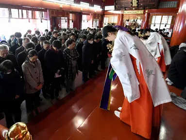 Gadis Shinto membunyikan lonceng selama upacara awal tahun di Kuil Kanda Myojin, Tokyo (4/1). Upacara tersebut diketahui sering dikunjungi oleh orang-orang yang mencari keberuntungan dan memiliki bisnis sukses. (AFP Photo/Toshifumi Kitamura)