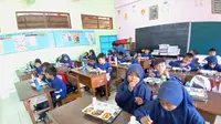 Sejumlah siswa di SDN di Sleman, DIY tengah menikmati makan siang yang dibagikan dalam program MBG. (Kukuh Setyono)