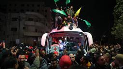 Sejumlah orang berkerumunan, bersorak, meneriakkan yel-yel dan membunyikan klakson mobil ketika dua bus yang membawa para tahanan tiba di Beitunia. (Zain JAAFAR/AFP)