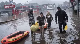 Warga menggunakan rakit karet untuk mengungsi setelah Sungai Meuse jebol saat banjir besar di Liege, Belgia, Kamis (15/7/2021). Hujan lebat dan banjir telah menewaskan sedikitnya 59 orang di Jerman dan sembilan di Belgia. (AP Photo/Valentin Bianchi)