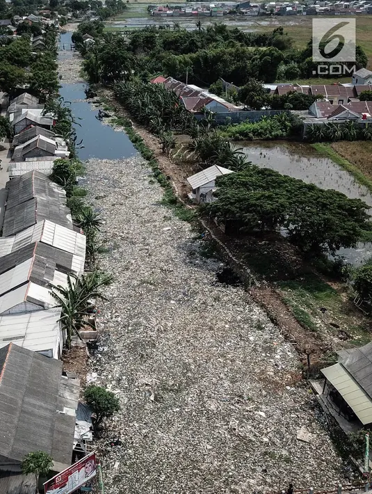 Pantauan dari udara, sampah yang menutupi Kali Pisang Batu, Tarumajaya, Kabupaten Bekasi, Rabu (9/1). Memasuki hari keempat dua alat berat dan puluhan truk dikerahkan untuk mengeruk sampah sekitar 300 ton yang sudah diangkut. (Liputan6.com/Fery Pradolo)