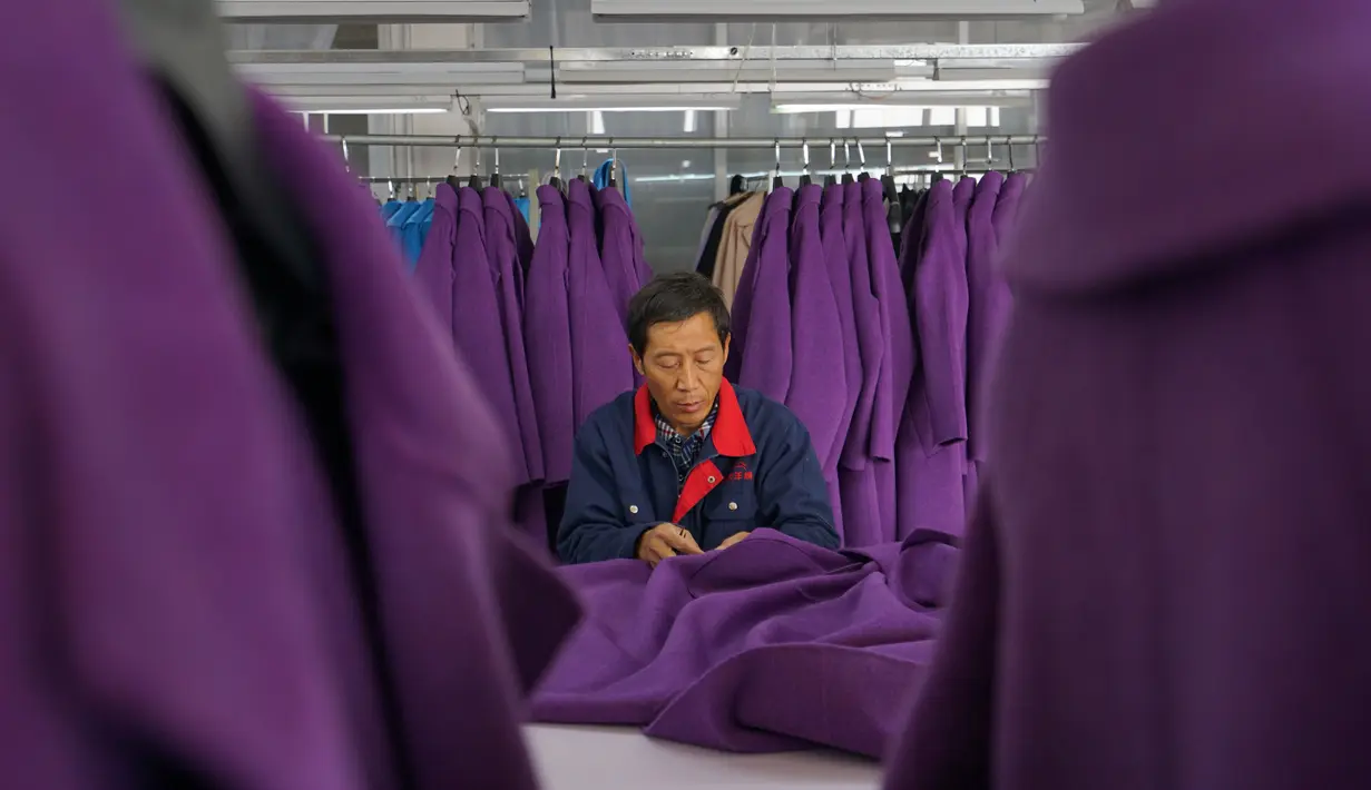 Seorang staf perusahaan kasmir menjahit mantel kasmir di wilayah Qinghe, Provinsi Hebei, China, 11 November 2020. Wilayah Qinghe telah membangun rantai industri kasmir yang lengkap mulai dari pembelian dan pemrosesan kasmir hingga pembuatan dan pemasaran garmen. (Xinhua/Mu Yu)