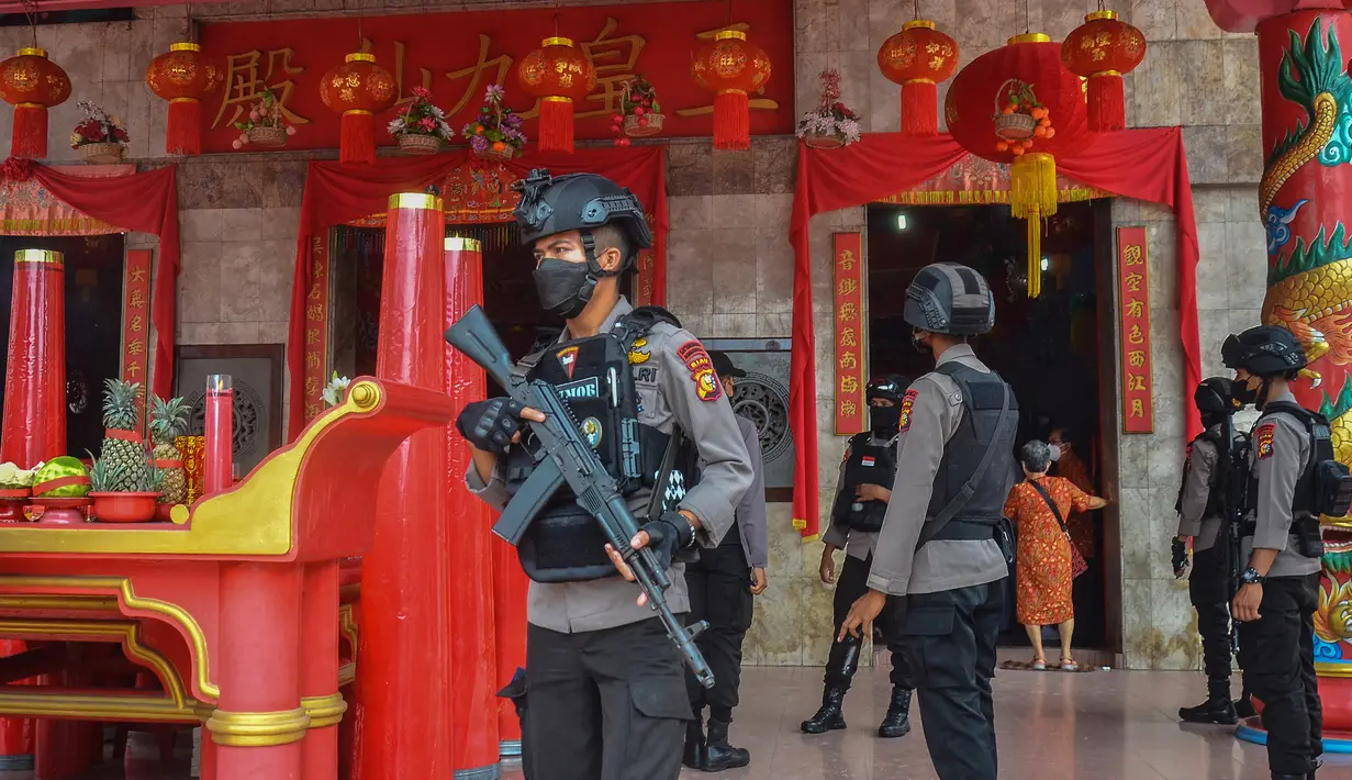 Anggota kepolisian melakukan patroli di luar kuil pada hari pertama Tahun Baru Imlek  di Pekanbaru, provinsi Riau pada 1 Februari 2022. (WAHYUDI / AFP)