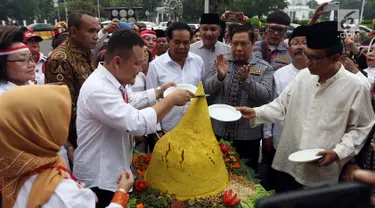 Relawan Indonesia Bersatu menggelar aksi potong tumpeng di depan Istana Negara, Jakarta, Jumat (5/7/2019). Aksi tersebut merupakan syukuran atas terpilihnya Joko Widodo atau Jokowi sebagai Presiden RI untuk kedua kalinya. (Liputan6.com/JohanTallo)