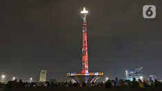 Suasana saat warga menyaksikan pertunjukan video mapping di Monumen Nasional (Monas), Jakarta, Minggu (22/12/2019). Acara ini berlangsung di pelataran barat Tugu Monas pada 22-31 Desember 2019. (Liputan6.com/Herman Zakharia)