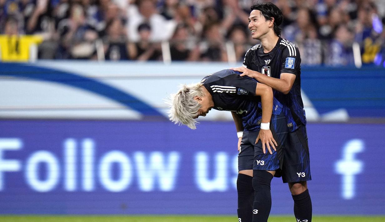 Pemain Jepang, Junya Ito (kiri) membungkukkan badan saat merayakan golnya ke gawang China pada laga putaran ketiga Grup C Kualifikasi Piala Dunia 2026 yang berlangsung di Saitama Stadium, Saitama, Jepang, Kamis (05/09/2024) WIB. (AP Photo/Shuji Kajiyama)