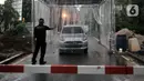 Petugas mengarahkan mobil saat memasuki bilik disinfektan di Perumahan Tamansari Persada Raya, Jatibening, Bekasi, Jawa Barat, Selasa (31/3/2020). Bilik disinfektan dipasang untuk mencegah penyebaran virus corona COVID-19 di area kompleks. (Iqbal S. Nugroho)