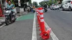Pengendara bermotor melintas di samping stick cone pembatas jalur sepeda di Kawasan Jalan Penjernihan Jakarta, Sabtu (10/12/2022). Keadaan stick cone untuk pembatas jalur sepeda tersebut terlihat sudah rusak dan tidak terpasang dengan benar. (Liputan6.com/Angga Yuniar)