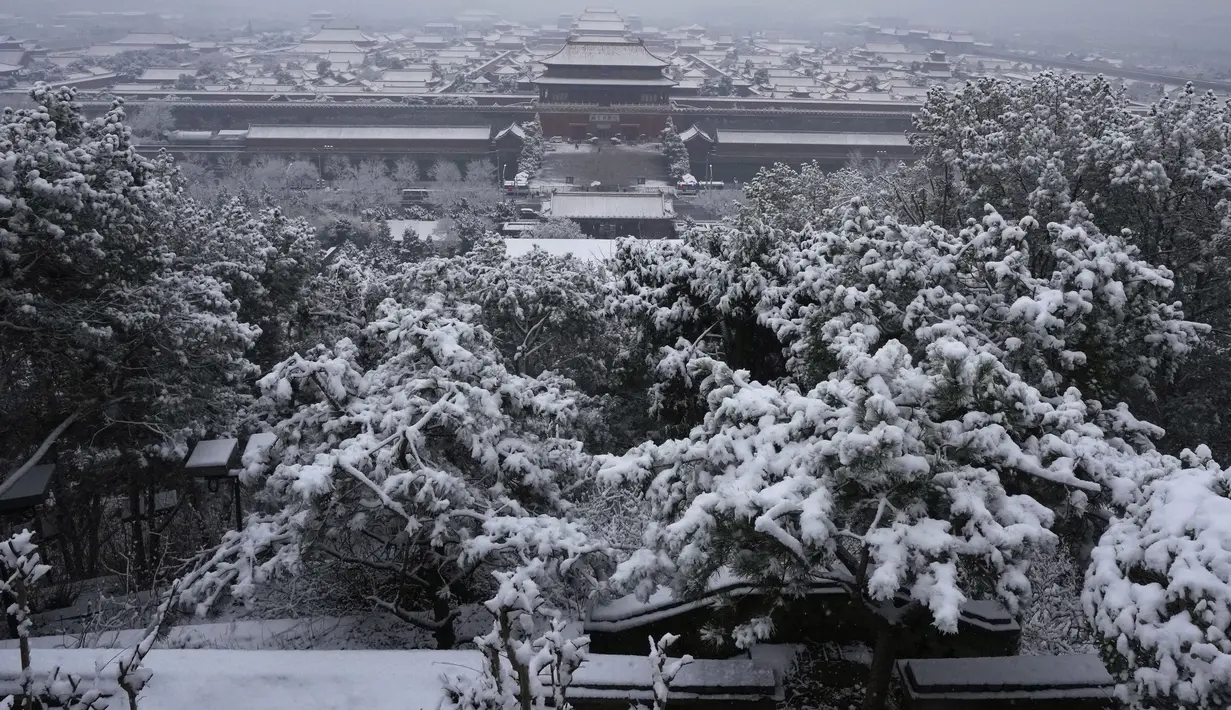 Pemandangan salju yang menutupi Kota Terlarang saat salju turun di Beijing, China (18/3/2022). Sebagian besar distrik di ibu kota China, Beijing, mengalami salju pada hari Kamis, dengan distrik paling utara Yanqing melaporkan hujan salju terberat. (AP Photo/Ng Han Guan)