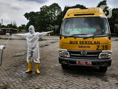 Petugas Kebersihan Bus (PKB) menyemprotkan disinfektan pada sopir bus sekolah saat proses dekontaminasi usai bertugas mengantarkan pasien terpapar Covid-19 di Pool Unit Pelayanan Angkutan Sekolah (UPAS) DKI Jakarta, Kramat Jati, Selasa (5/1/2021). (merdeka.com/Iqbal Nugroho)