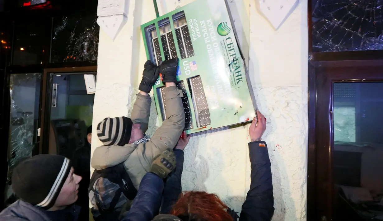 Para demonstran saat merusak fasilitas bank Rusia, Sberbank di Kyiv, Ukraina, (21/11). Selain menghancurkan bank massa memblokir lalu lintas dan membakar barang-barang di depan alun-alun. (REUTERS/Valentyn Ogirenko)