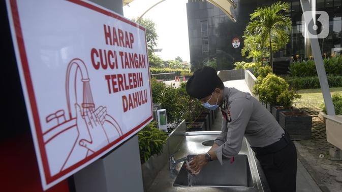 Polisi mencuci tangan sebelum memasuki Gedung KPK, Jakarta, Senin (30/3/2020). KPK menyediakan fasilitas cuci tangan bagi pengunjung, karyawan, serta petugas keamanan sebelum memasuki gedung guna mencegah penyebaran virus corona COVID-19. (merdeka.com/Dwi Narwoko)