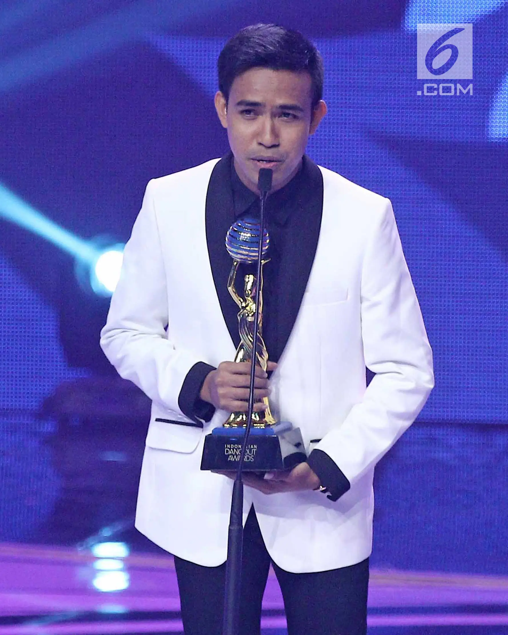 Fildan menerima piala untuk kategori penyanyi dangdut pendatang baru pria terbaik dalam ajang Indonesian Dangdut Awards 2017 di Studio 6 EMTEK CITY, Jakarta, Jumat (13/10). (Liputan6.com/Herman Zakharia)