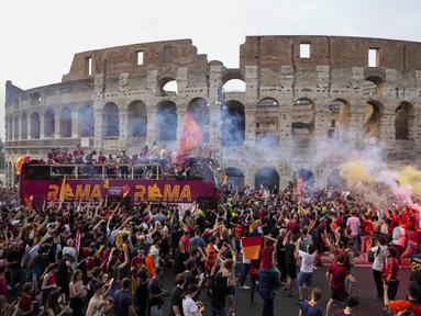 Bus tim AS Roma melaju di tengah kerumunan pendukung yang bergembira saat merayakan kemenangan juara Liga Konferensi Eropa UECL di depan Colosseum di Roma (26/5/2022). AS Roma menjuarai Konferensi Eropa UECL setelah mengalahkan Fayenoord dengan skor tipis 1-0. (AP Photo/Gregorio Borgia)