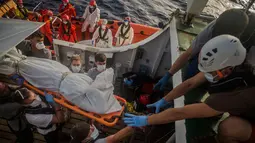Petugas LSM Spanyol mengevakuasi jasad imigran Afrika sub-Sahara di tengah Laut Mediterania, lepas pantai Libya, Selasa (25/7). Dalam operasi penyelamatan, petugas menemukan 13 jasad di atas perahu karet yang membawa 160 orang migran. (AP/Santi Palacios)