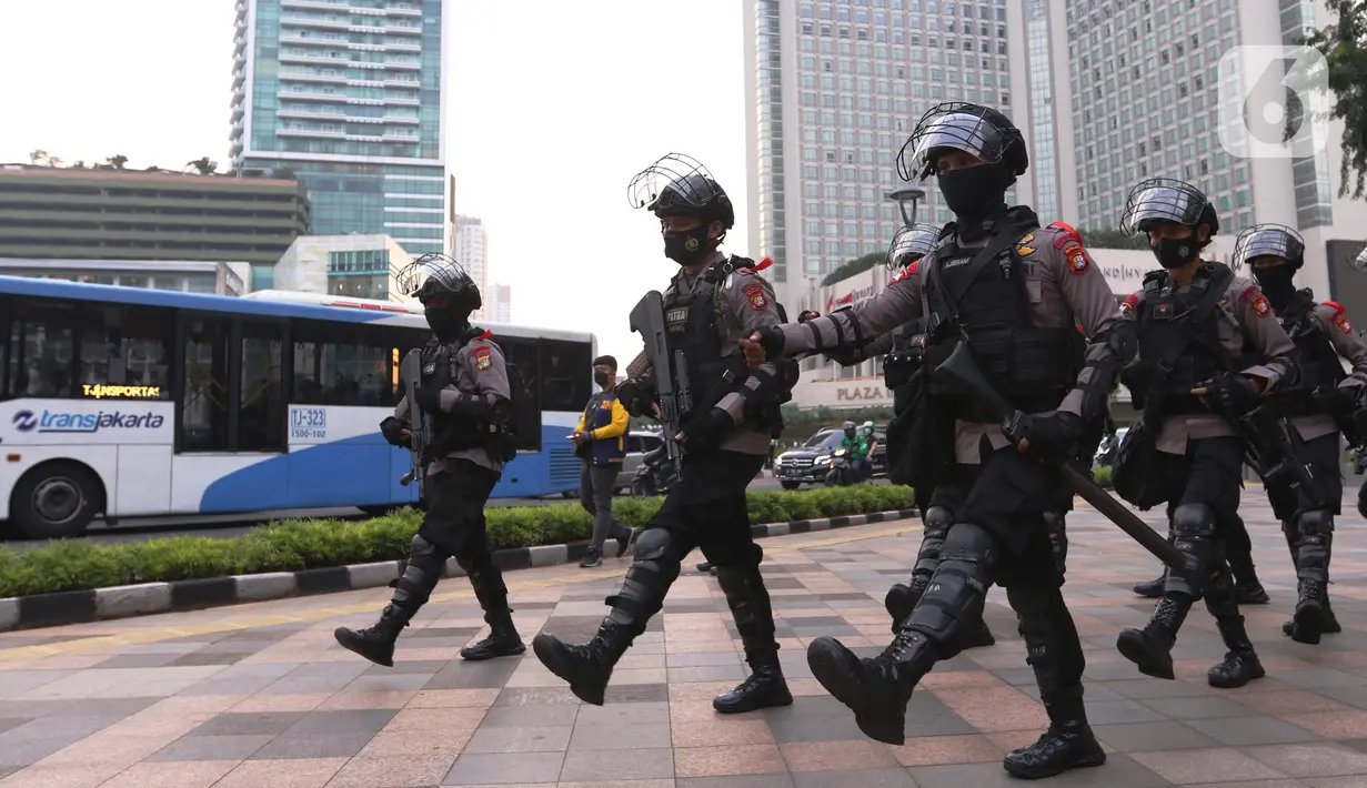 Aparat kepolisian bersenjata lengkap melakukan patroli di kawasan Bundaran Hotel Indonesia (HI),  Jakarta, Rabu (12/5/2021). Pengamanan ketat tersebut dilakukan untuk menjaga perayan Idul Fitri 1442 di jantung Ibu Kota. (Liputan6.com/Angga Yuniar)