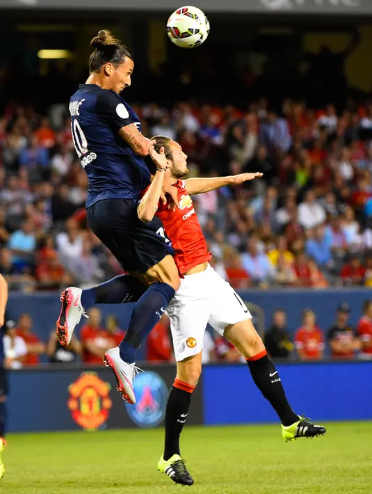 Penyerang PSG, Zlatan Ibrahimovic berebut bola udara dengan pemain MU Daley Blind di stadion soldier, Chicago, AS, Kamis (30/7/2015). Paris Saint – Germain menang dengan skor 2-0 atas Manchester United. (Reuters/Mike diNovo) 