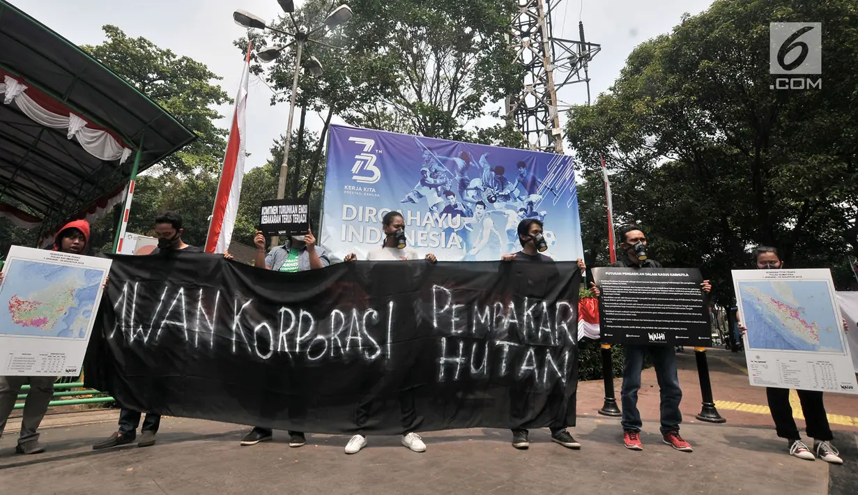 Aktivis WALHI  membentangkan spanduk dalam aksi protes pembakaran hutan di depan Kantor KLHK, Jakarta, Senin (27/8). WALHI menuntut pemerintah menegakkan hukum bagi korporasi pembakar hutan yang berlangsung setiap tahun. (Merdeka.com/Iqbal S. Nugroho)