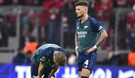 Pemain Arsenal, Martin Odegaard dan Ben White, tampak kecewa setelah ditaklukkan Bayern Munchen  pada leg kedua perempat final Liga Champions di Allianz Arena, Kamis (18/4/2024). (AP Photo/Christian Bruna)