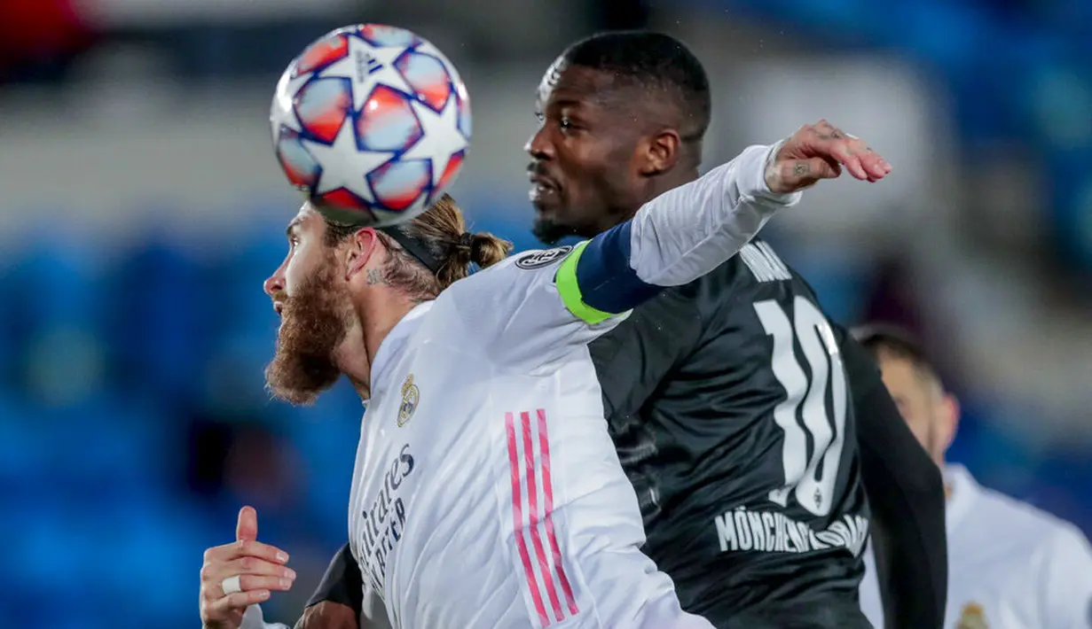 Bek Real Madrid, Sergio Ramos, duel udara dengan pemain Borussia Monchengladbach, Marcus Thuram, pada laga Liga Champions di Stadion Alfredo Di Stefano, Kamis (10/12/2020). Real Madrid menang dengan skor 2-0. (AP/Bernat Armangue)