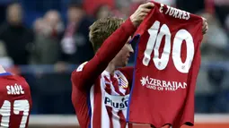 Pemain Atletico Madrid, Fernando Torres, mengangkat kaus bertuliskan 100 gol yang telah dicetaknya bersama Atletico Madrid pada lanjutan La Liga Spanyol di Stadion Vicente Calderon, Sabtu (6/2/2016). (EPA/Javier Lizon)